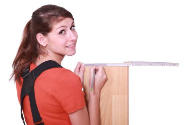 Female woodworker measuring a board clipart