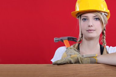 Woman resting on wooden beam with hammer clipart