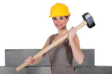 Attractive construction worker holding a mallet clipart