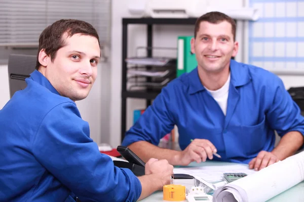 Två manuella arbetare på kontoret kontrollera lagernivåer — Stockfoto