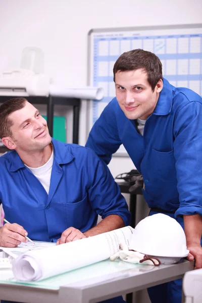 Dois trabalhadores da fábrica no escritório verificando estoque — Fotografia de Stock