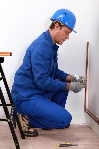 Travailleur de la construction installant un tuyau — Photo