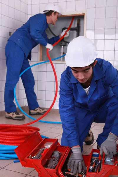 Laborers installing tube — Stock Photo, Image