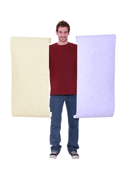 Man holding two rolls of pastel wallpaper — Stock Photo, Image
