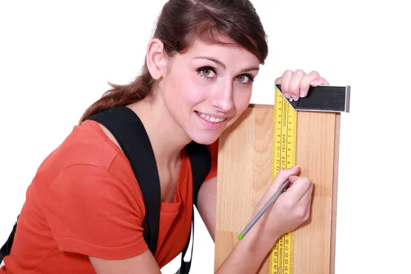 Kobieta oznakowanie deski z drewna przy użyciu zestaw plac — Zdjęcie stockowe