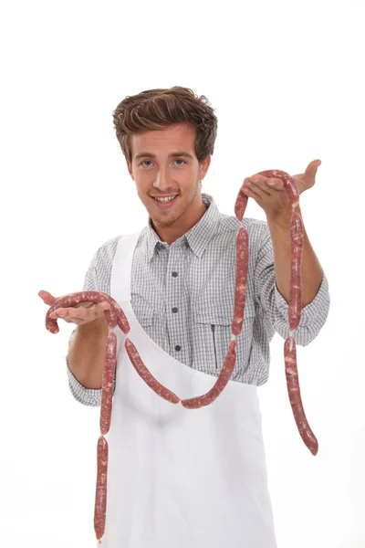 Carniceiro jovem com salsichas — Fotografia de Stock