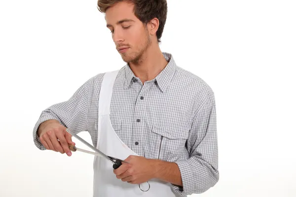 Young man sharpening knife — Stock Photo, Image