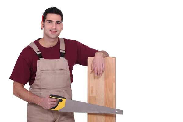 Carpinteiro com soalho e uma serra manual — Fotografia de Stock