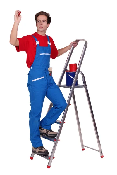 Pintor em uma escada rolante e segurando um selo — Fotografia de Stock