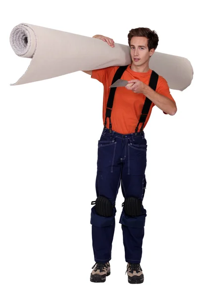 Homem que transporta rolo de tapete — Fotografia de Stock