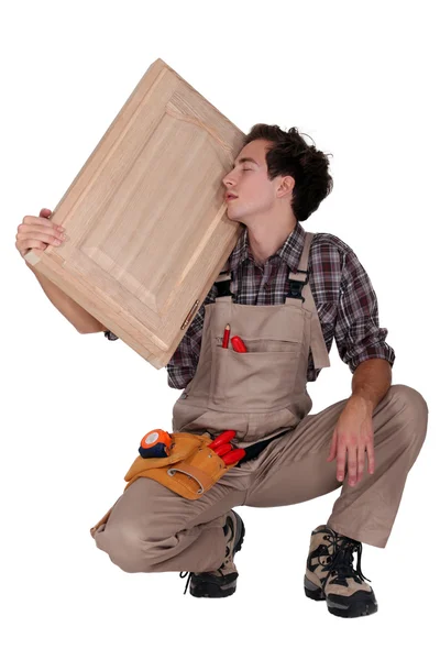 Ξυλουργός κρατώντας ένα ξύλινο κούφωμα — Φωτογραφία Αρχείου