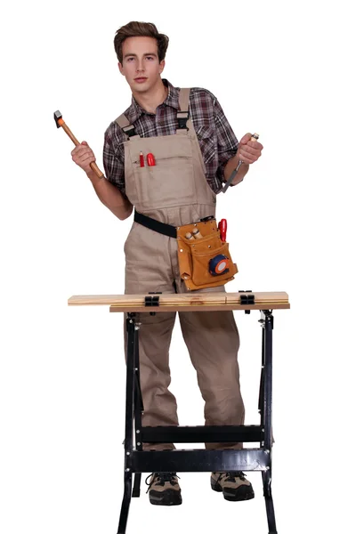 A tradesman standing behind a workbench — Stock Photo, Image