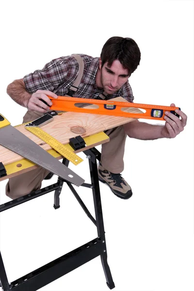 Carpenter leveling plank — Stock Photo, Image