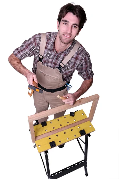 A carpenter making a wooden frame — Stock Photo, Image