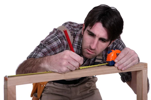 男子测量木制框架 — 图库照片