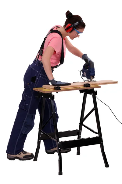 Kadın marangoz bir testere kullanarak. — Stok fotoğraf