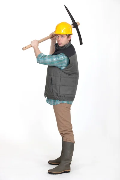 Young bricklayer in profile holding pickaxe — Stock Photo, Image