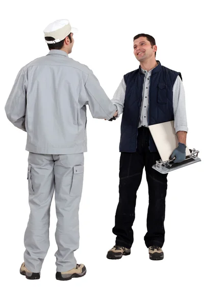 Tile cutter shaking hands with other worker — Stock Photo, Image