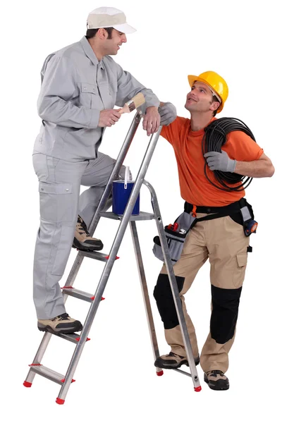 Hantverkare målare på en stege att tala med en kollega — Stockfoto