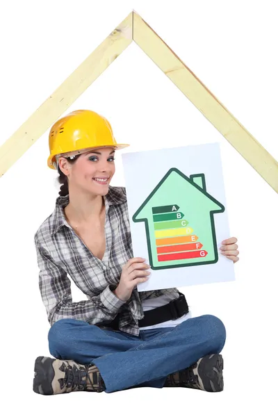 Trabajadora de la construcción con un signo de calificación energética — Foto de Stock