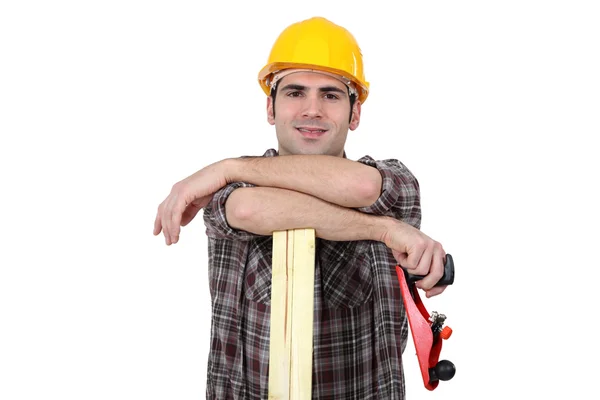 Carpenter posing with plank of wood and plane — Stock Photo, Image