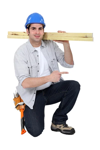 Construtor carregando madeira no ombro — Fotografia de Stock