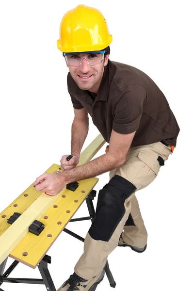 Tradesman using a plane to smooth a plank of wood — Stock Photo, Image