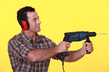 Man protecting his ears whilst drilling clipart