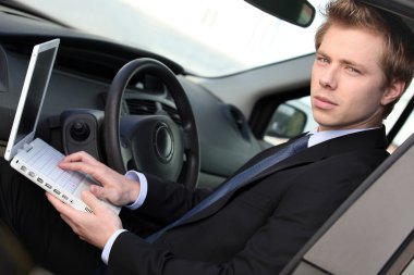 Man with computer in car clipart