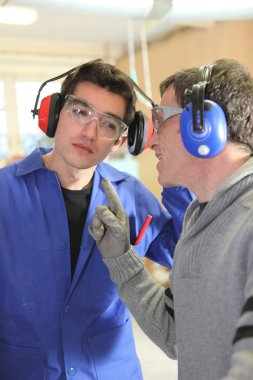 Men talking in a factory clipart