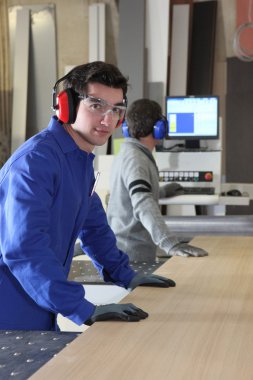 Two factory workers using band-saw clipart