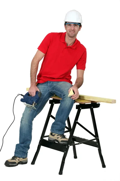 Homem cortando um pedaço de madeira com um quebra-cabeça — Fotografia de Stock