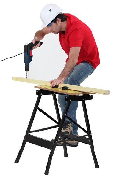 Carpenter drilling into wooden plank — Stock Photo, Image