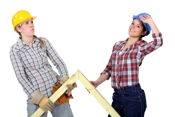 Women lifting wooden triangle — Stock Photo, Image