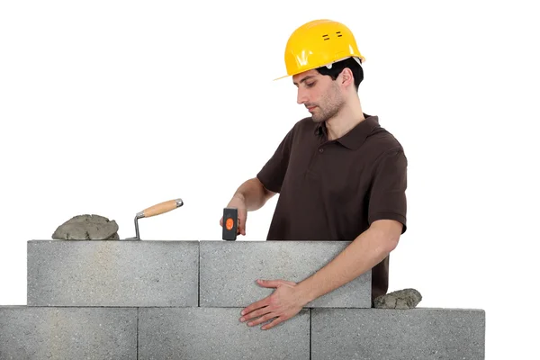Mason knocking bricks into place with hammer — Stock Photo, Image