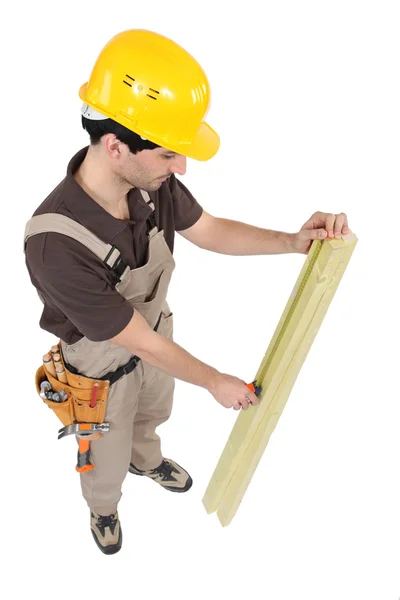 Плотник, измеряющий деревянную доску — стоковое фото
