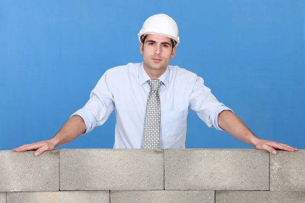 Engenheiro em pé sobre uma parede de pedra — Fotografia de Stock
