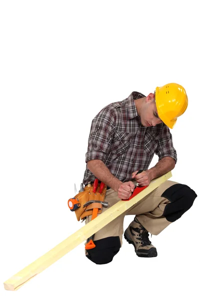 Плотник за работой затачивает древесину — стоковое фото