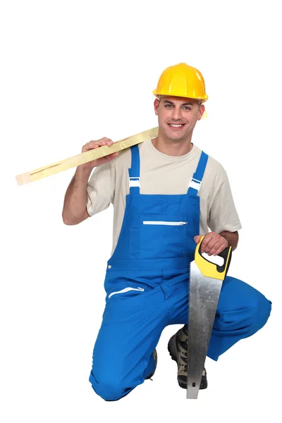 Un falegname inginocchiato con una sega a mano . — Foto Stock