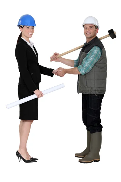Businesswoman shaking the hand of a tradesman — Stock Photo, Image
