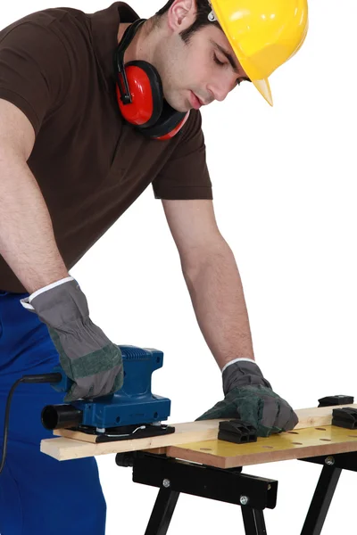 Carpinteiro no trabalho com máquina de lixadeira — Fotografia de Stock