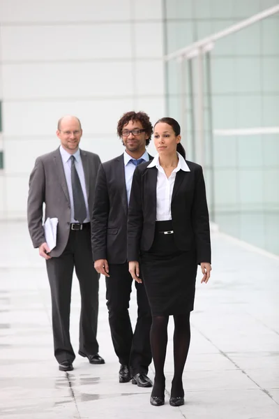 A team of businesspeople waking their way into their office block — Stock Photo, Image