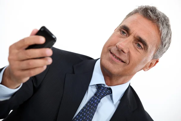 Starší muž, kontrola jeho mobil — Stock fotografie