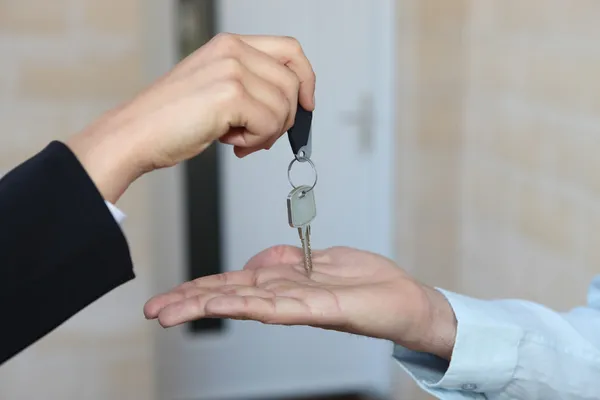 Estate-agent handing over house keys — Stock Photo, Image