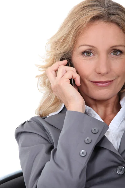 A businesswoman phoning and looking at us. — Stock Photo, Image
