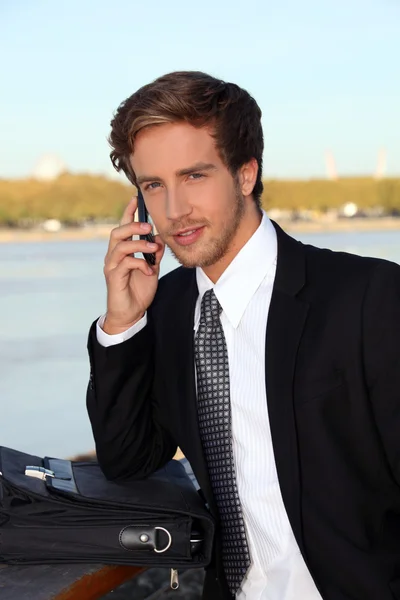 Executive on the phone at a riverside — Stock Photo, Image