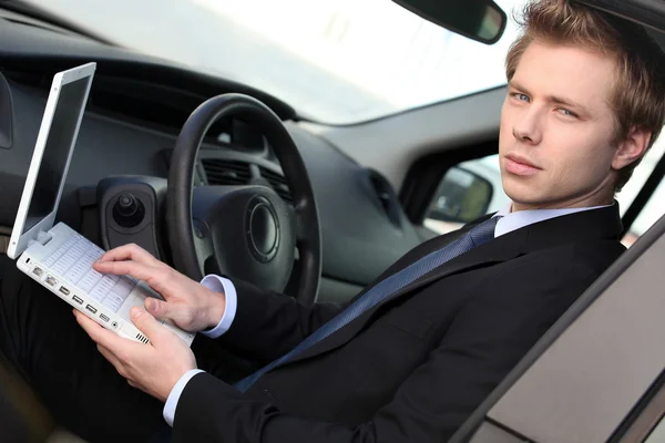 Man with computer in car — Stock Photo, Image