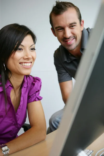 Счастливые молодые женщина и мужчина, работающие на ноутбуке — стоковое фото