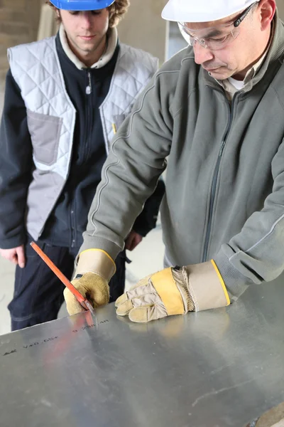 Инженер резки листового металла с учеником — стоковое фото