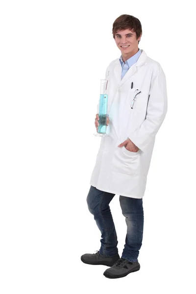 Mavi sıvı dolu kabı tutan genç bilim öğrenci — Stok fotoğraf